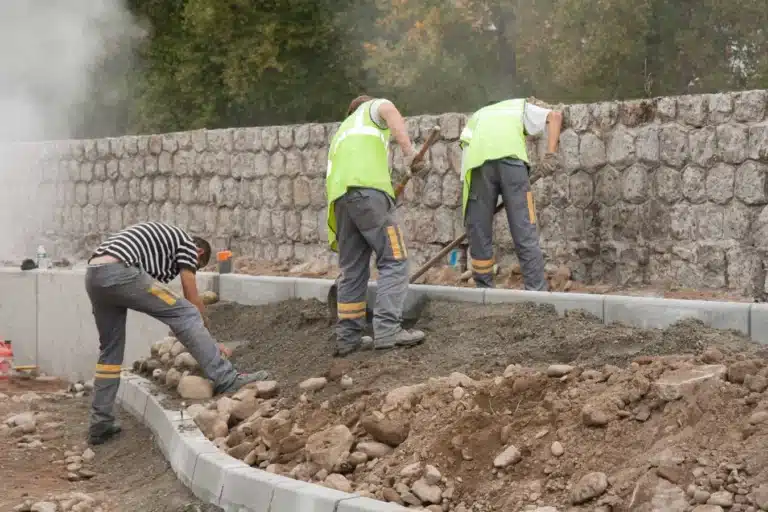 Maçons montant un mur de soutènement en pierre